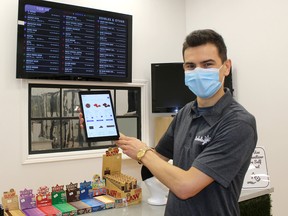 Chris Colasanti, a partner in Herbologi, a new retail cannabis store at 138 King St. W. in downtown Chatham, displays one the tablets customers use to browse the products for sale. Ellwood Shreve/Postmedia Network