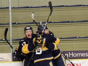 The Spruce Grove Saints defeared the Sherwood Park Crusaders 4-3 in overtime on Friday to kick off the AJHL season. Below Graham Gamache, Logan Acheson, and Breck McKinley celebrate the overtime winning goal.