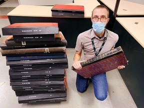 County archivist Joshua Klar with bound volumes of The Simcoe Reformer and The Delhi News-Record that were recently donated to the Norfolk County Archives in downtown Simcoe. – Monte Sonnenberg