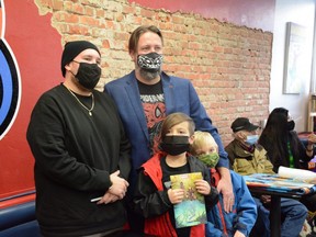 Marvel artist Kyle Charles (left), contributor to Marvel's Indigenous Voices comic, stands next to Wonderland owner Vincent Joyall along with Joyall's children at Wonderland in Grande Prairie, Alta. on Saturday, Nov. 21, 2020.