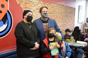 Marvel artist Kyle Charles (left), contributor to Marvel's Indigenous Voices comic, stands next to Wonderland owner Vincent Joyall along with Joyall's children at Wonderland in Grande Prairie, Alta. on Saturday, Nov. 21, 2020.