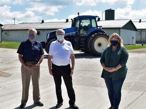 Ontario Minister of Agriculture, Food & Rural Affairs, Ernie Hardeman, centre, Perth-Wellington MPP Randy Pettapiece (left), and Huron-Bruce MPP Lisa Thomspon announce an increase of provincial funding for the Risk Management Program during a stop at Monoway Farms in Brussels on July 17. (Daniel Caudle/Postmedia Network)