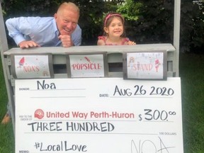United Way campaign co-chair Martin Ritsma accepts a $300 donation from Noa Minor, 5, who raised the funds by selling individually wrapped popsicles in her front yard. (Submitted photo)