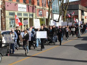 Protesters opposed to a bylaw requiring face masks to be worn when inside public places marched through downtown Chatham on Saturday. Ellwood Shreve/Postmedia Network