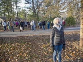 Romayne Smith-Fullerton and her Port Franks neighbours are urging council to do something about the town's gypsy moth infestation. She is standing with a pine tree the group says was killed by gypsy moth caterpillars. Derek Ruttan/The London Free Press