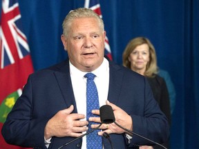 Ontario Premier Doug Ford answers questions during the daily briefing at Queen's Park in Toronto on Monday as Health Minister Christine Elliott listens. FRANK GUNN / THE CANADIAN PRESS