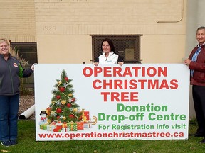 Dynamic Graffix Signs & More’s Tracey Manchester (left), Exit Realty Twin Bridges’ Nicole Smith (centre) and Operation Christmas Tree president Stan Marsh (right) unveil the 2020 sign for Operation Christmas Tree at their OPP Emergency Services Building headquarters at 392 Lyndoch St. in Corunna. Carl Hnatyshyn/Sarnia This Week