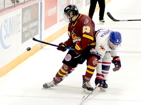 Timmins Rock forward Cameron Kosurko uses his body to shield the puck away from Canadians blue-liner Avery Chisholm along the boards to the left of the Rayside-Balfour net during the second period of Saturday night’s NOJHL game at the McIntyre Arena. Kosurko’s first-period power-play goal proved to be the game-winner as the Rock defeated the Canadians 4-1 to take five of the six games in their season-opening series. THOMAS PERRY/THE DAILY PRESS