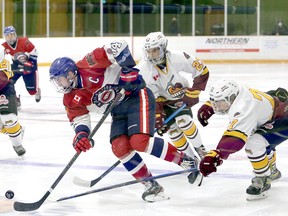 Timmins Rock forward Harry Clark reaches in to knock the puck off the stick of Rayside-Balfour Canadians captain Brady Maltais during Thursday night’s NOJHL game at the Chelmsford Arena. The Canadians scored three goals in a span of 21 seconds in the third period to register a 7-4 victory — their first of the season. BEN LEESON/POSTMEDIA NETWORK