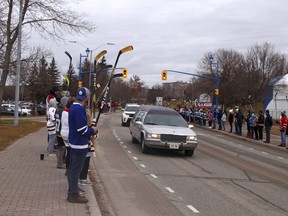 Crowds of people raise their sticks in the air along Memorial Drive in honour of 13-year-old Noah Dugas, a AAA North Bay Trappers hockey player whose funeral took place Saturday morning. Michael Lee/The Nugget