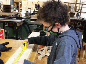 This enterprising young student is taking great care to measure the length of the board properly before it is cut. Each board was cut into equal two foot lengths for a special project the AB Ellis students are working on for the Espanola nursing home seniors.