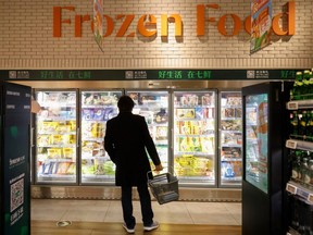 A customer looks at products in the frozen food section at JD's 7Fresh supermarket on China's Singles Day shopping festival during a government organized tour in Beijing, China November 11, 2020. (REUTERS/Thomas Peter)