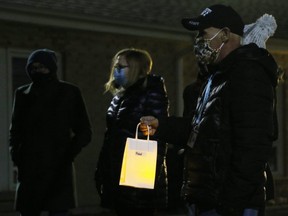 Reach Out Chatham-Kent (ROCK) Missions volunteer Jeff Parker holds a candle bag during a vigil at Chatham-Kent United Way in Chatham, Ont., on Saturday, Nov. 28, 2020, to remember four homeless friends who died in 2020. Mark Malone/Chatham Daily News/Postmedia Network
