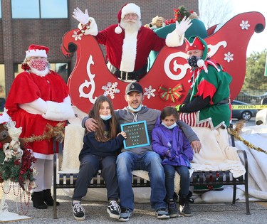 Marcus Barry and his daughters Sierra, 10, left, and Selena, 8, pose with Santa Claus at the Historic Downtown Chatham Business Improvement Area parking lot in Chatham, Ont., on Saturday, Nov. 28, 2020. Mark Malone/Chatham Daily News/Postmedia Network