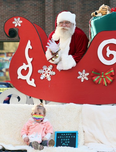 Twenty-month-old Paisley King sits for a socially distanced photo with Santa Claus at the Historic Downtown Chatham Business Improvement Area parking lot in Chatham, Ont., on Saturday, Nov. 28, 2020. Mark Malone/Chatham Daily News/Postmedia Network
