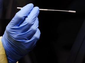 A nurse uses a swab to perform a test on a patient.