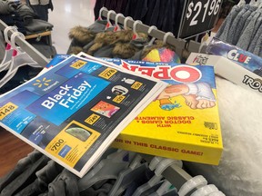 Black Friday ads lay on top of clothes at Walmart.
