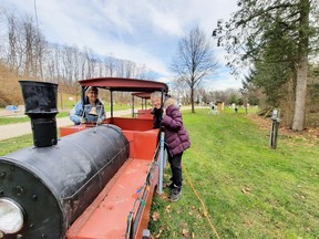 Mary Nichols and Marianne Batte put lights on the Formosa Country Christmas train that will soon be chugging up to the train station, pictured in the background.