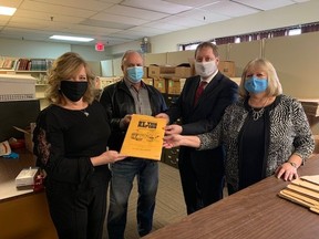 Sault Star advertising manager Maureen Montanini hands over The Sault Star archives to Sault Ste. Marie Public Library board chair Wayne Greco, CEO Matthew MacDonald and manager of public services Sharon Wigney.