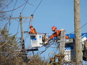 Utilities Kingston crews repair utility poles on Sir John A. Macdonald Boulevard after a collision damaged them early Monday morning. (Elliot Ferguson/The Whig-Standard)