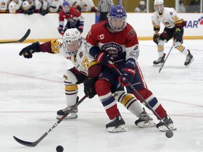 Rayside-Balfour Canadians forward Gavin Brown (23) plays the puck under pressure from Timmins Rock defenceman Eric Moreau (27) during NOJHL action at Chelmsford Arena in Chelmsford, Ontario on Thursday, November 19, 2020.