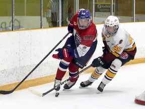 Rayside-Balfour Canadians forward Oliver Smith (22) handles the puck under pressure from Timmins Rock defenceman Bode Dunford (25) during NOJHL action at Chelmsford Arena in Chelmsford, Ontario on Thursday, November 19, 2020.