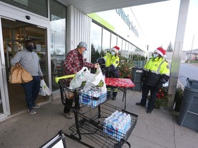 FreshCo shoppers drop off donated items to paramedics during the annual Frontenac Paramedics food drive for Partners in Mission Food Bank on Saturday.