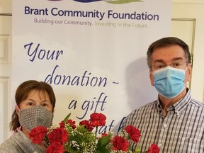 In a not-so-random act of kindness, Jim Steele, right, who sits on the board of the Brant Community Foundation, presents the foundation's executive director, Joanne Lewis, with a bouquet leading up to Random Act of Kindness Day on Nov. 6.