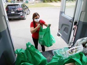 In this file photo, Lynne Ethier, manager of fundraising and community engagement for Our Children, Our Future, loads a van provided by Cambrian Ford, with bags of food prepared for families for Thanksgiving. John Lappa/Sudbury Star