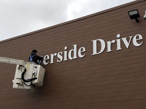 Norm Gibeau of Modern Signs installs letters on the west face of the recently renovated Riverside Centre at 359 Riverside Dr.