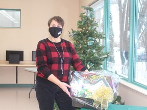 Library CEO Christina Blazecka displays one of the dozen baskets that will be available for patrons to bid on..TP.JPG