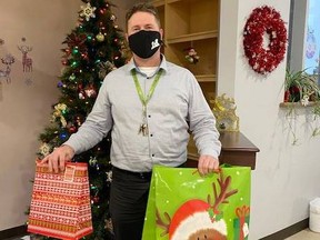 Rodney Hoogenhoud,  Executive Director for Cochrane Family Health Team is holding gifts that will be part of what he hopes is many that will go to the Villa Minto residents for Christmas. .TP.jpg