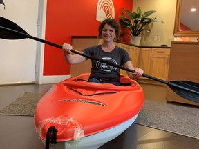 United Way donor relations director Melanie Cressman shows off the kayak and paddle donated by Belleville's Canadian Tire store. It's one of the items available to be won in the United Way virtual auction.