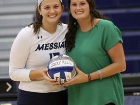 Paris native Holly Motheral presents a game ball to Mary Underman, a two-time All-American who reached 1,000 kills last season. Motheral is the head coach of the women's volleyball team at Messiah University in Pennsylvania.