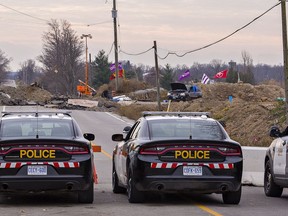OPP vehicles sit on McKenzie Road in Caledonia on Friday as the occupation by Indigenous protesters of a residential development continues.