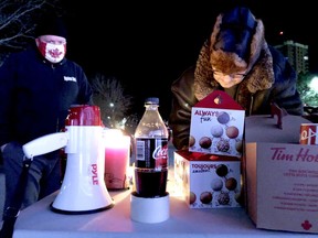 Leigh Bursey, left, watches as Richard Bradley signs a list of participants in One Cold Night by the Brockville Railway Tunnel on Friday night. (RONALD ZAJAC/The Recorder and Times)