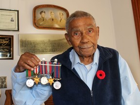John Olbey, 98, earned several medals while serving as a Sergeant in the 4th Canadian Armoured Division/Headquarters during the Second World War. He is pictured on the left, in the photo behind him, with his brothers George, in the middle, who served in the Signal Corps, and Wilfred, who served in the forestry unit in British Columbia. He is also in the group photo of the Fourth Canadian Armoured Brigade take in June 1944 in Marsfield, England. Ellwood Shreve/Chatham Daily News/Postmedia Network