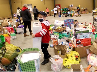 Hayden Liberty, 8, of Chatham was among the volunteers who helped sort through donations of food and toys that local residents gave to The Gift CK, which was held across Chatham-Kent on Saturday. Ellwood Shreve/Chatham Daily News/Postmedia Network