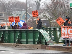 Several people braved the rain to take part in the Rally on the Bridge, held on the Third Street Bridge in Chatham on Wednesday. This is the seventh year a rally to end violence against women has been organized by the Zonta Club of Chatham-Kent. (Ellwood Shreve/Chatham Daily News)