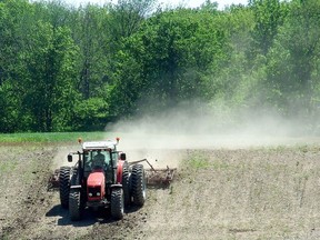 An area farmer working the fields. POSTMEDIA FILE PHOTO