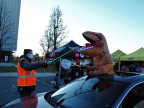 A Your TV volunteer feeds the mouth of T-Rex trick or treater during Cornwall Optimist Club Trunk or Treat event at the civic complex, Friday, Oct. 31, in Cornwall, Ont. Greg Peerenboom/Special to the Cornwall Standard-Freeholder/Postmedia Network