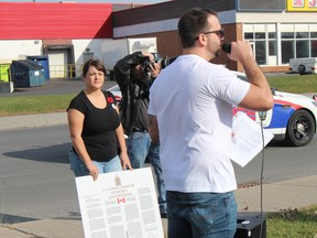 Two of the event organizers, Caitlyn Richer in background while Chris Leclair speaks to the crowd. Photo Saturday, November 7, 2020, in Cornwall, Ont. Todd Hambleton/Cornwall Standard-Freeholder/Postmedia Network