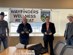 Wayfinders Wellness Retreat founders Paul Wagman (far left) and Bryce Talsma (far right) present local volunteers Dan Kroffatt (inner left) and Alex Baum with their new ‘Wayfinder Appreciation Award’ in recognition of the pair’s volunteer support. Patrick Gibson/Cochrane Times