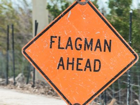 Flagman ahead traffic road sign in red, orange color, signal for drivers on overseas highway road, US1 about utility, construction, repair work, workers