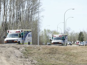 Ambulances head south near Gregoire Lake, near Anzac, Alta., on Wednesday May 4, 2016.  Ian Kucerak/Postmedia Network