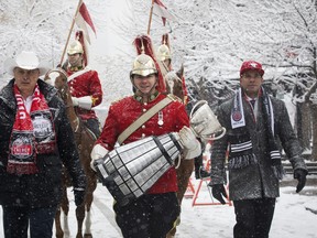 CFL commissioner Randy Ambrosie (left) and former Calgary Stampeders great Jon Cornish (right) walk with the Grey Cup and members of the Lord Strathcona’s Horse while celebrating the arrival of the Grey Cup in Calgary, on Nov. 19, 2019. Grey Cup Week would have been this week.