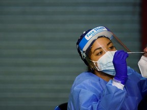 A health-care worker performs a rapid COVID-19 antigen test.