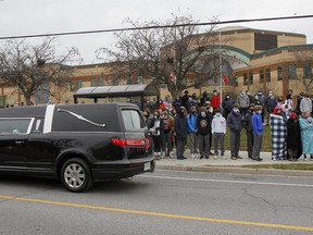 Staff and students at Holy Cross Catholic Secondary School line Woodbine Road in silence in front of the school as the funeral procession for Scottie Legg, 16, passes by the school after the teen's celebration of life and stopped for a moment of silence in Kingston on Tuesday. (Julia McKay/The Whig-Standard)