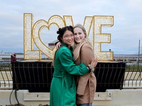 Karen Au and Hilary Parson stand in front of the newly installed Love sign at Confederation Park in downtown Kingston on Saturday.