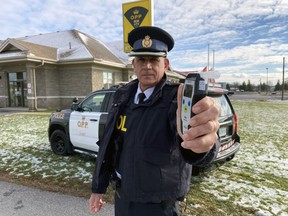 Insp. Scott Semple, detachment commander of the Lennox and Addington County Ontario Provincial Police, with an alcohol roadside screening device in Napanee on Monday.